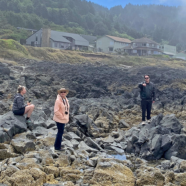 Jennell, Virginia, and Sebastian on the rocks at Yachats.