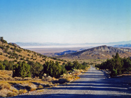 A valley with steep sides, with a two-lane road passing through.