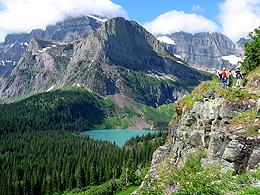 Children at the top of a cliff with mountains in the background