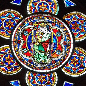 Mary on throne with Jesus Mary sits upon a throne; she is holding Jesus, and kissing him.