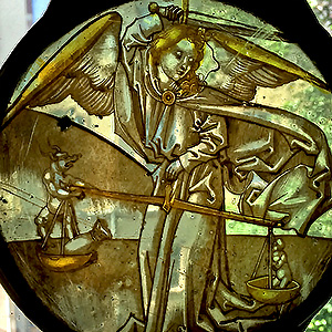 Saint Michael weighs the merit and sin of a soul, holding a balance scale in his left hand and raising his sword with his right arm.