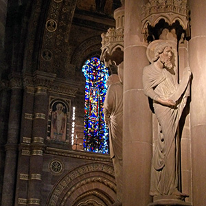 Inside the cathedral Statue inside the cathedral with stained glass behind it