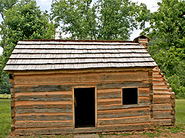 A log cabin with one door and one window.