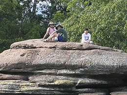Family sitting up on the top of the cliff.