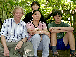 The family sitting on a wooden step on the trail at Giant City.