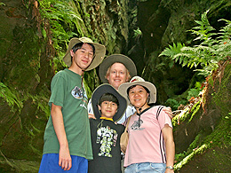 The family in Ferne Clyffe State Park posing in front of a chasm with ferns and shaded mosses