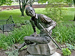 A statue of the composter Stephen Foster showing him sitting and holding a stick