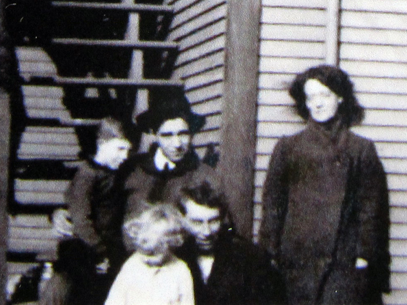 An old photograph from 1915 with Grandpa holding a bucket in one hand and holding his mom's hand in the other hand