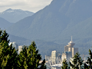 Vancouver seen from Elizabeth Park with a telephoto lens, the mountains tower behind the buildings.