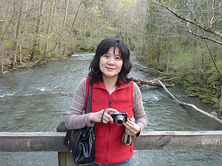 Jeri with her red vest standing on a bridge