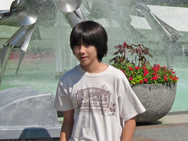 Boy standing in front of crab fountain