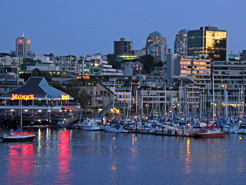 False Creek with lights of restaurant reflected in the water and many boats moored