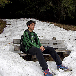 Arthur sits on a bench amid a snow bank.