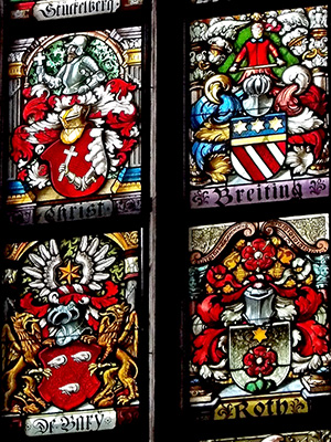Between 1893 and 1897 the prominent and wealthy families of Basel donated money to help found the Historisches Museum, and to get their family armorial panels up in the Barfüsserkirche. Franz Joseph Merzenich, Heinrich Drenckhahn, and the Meyner & Booser glass painting studio produced these panels, and 107 of them can still be seen when you visit the museum.在1893年至1897年間的瑞士巴塞爾，一些身世顯赫的富貴家族響應捐款，贊助這間歷史博物館成立。贊助者的家族徽章被製成彩色玻璃面板，得以鑲在這所巴福社教堂裡。由梅策尼希，德恩克漢，梅兒和布塞玻璃彩繪工作室參與製作，至今館中尚存107幅。