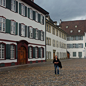 Jeri stands on coblestones in front of old houses in Basel.