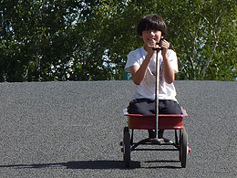 Arthur riding a red wagon down a hill