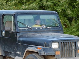 Sebastian driving the jeep through an apple orchard