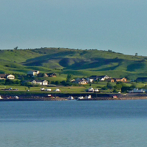 Wide river with grassy hills far off across the river