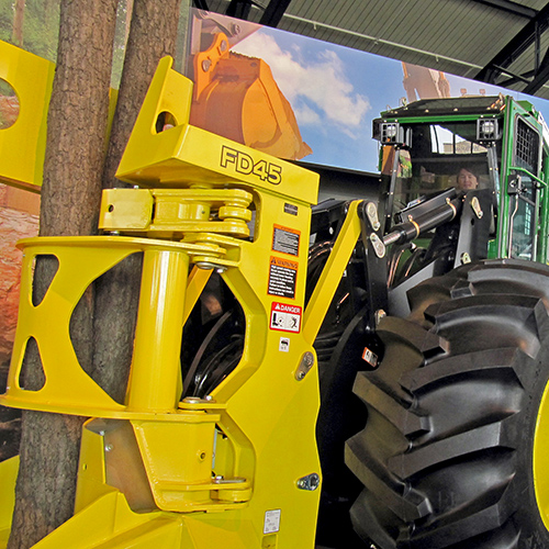 A sort of tractor with a large device in front that can grab a tree and cut it down and lift it up.