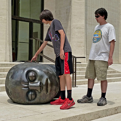 A large head lies on a concrete staircase