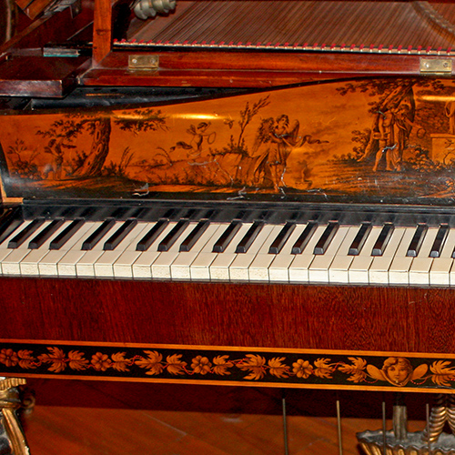 A piano with much painting and decoration.