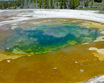 Clouds reflected in a green hot spring pool.