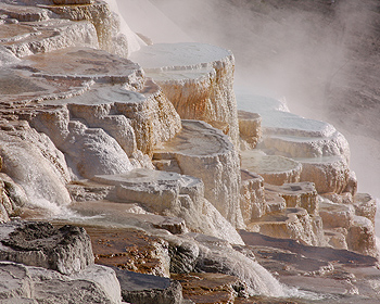 Looking down a steep slope at travertine structures