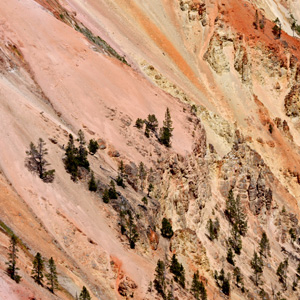 Rocks on steep canyon slopes in many colors of pink, orange, yellow, and red