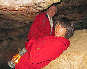 Arthur leaning against a rock in the cave