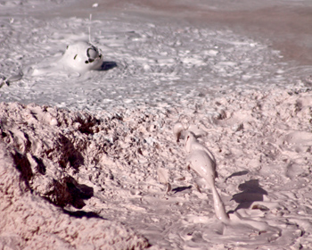 thick mud splattering as bubbles rise through it