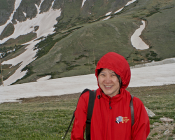 Jeri with snow and alpine meadows behind her