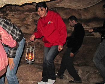 Jeri holding a lantern in the cave