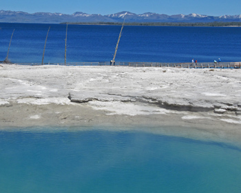Light blue spring with dark blue lake behind it
