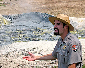 A ranger gestures with a muddy mess in the background