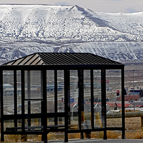 Bus stop with snowy bluffs in the distance behind it.