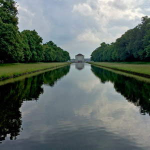 The sky is reflected in the canal at Nymphenbourg Palace in Munich, Germany