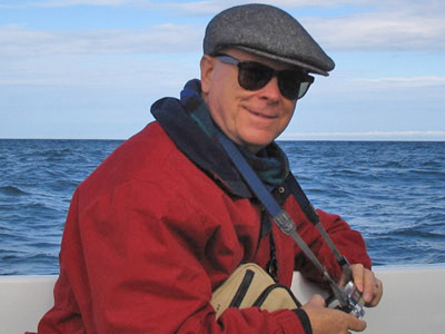Photograph of Peter Janke with camera, at sea.