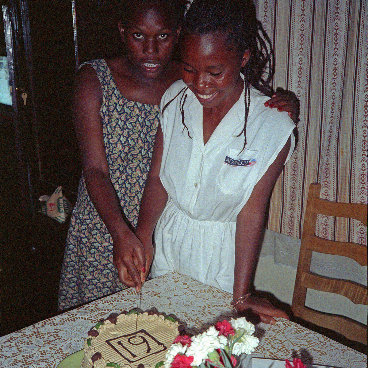 Lillian cuts the cake with the number 19 on it