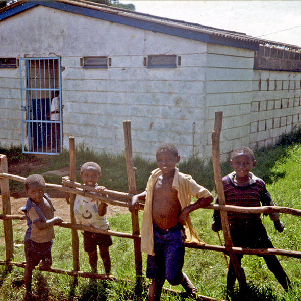 Four neighborhood boys pose in front of the Wambua home in Kibera