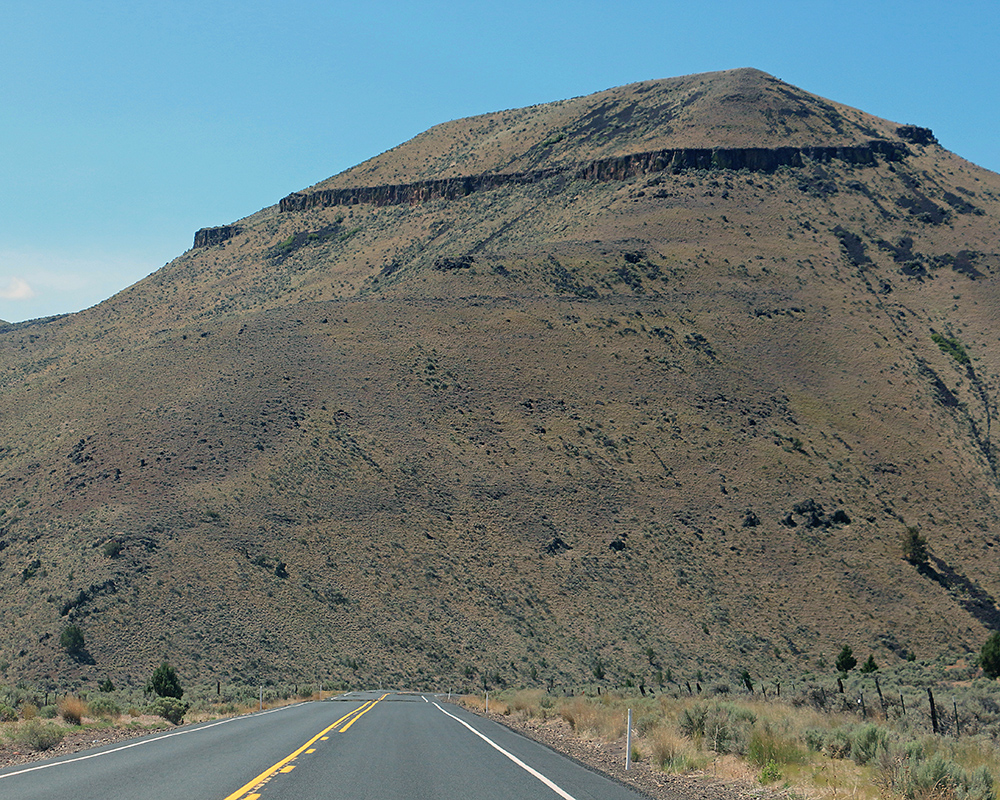 Cliffs rise up from trees along the Malheur River