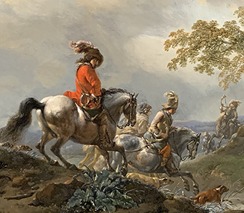 A man sits atop his horse, looking dashing in his read jacket with a feather blowing in wind upon his hat.