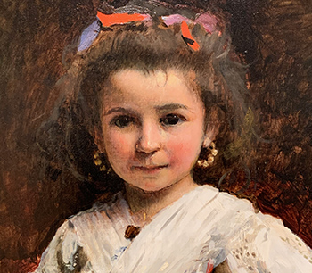 The young girl seems to be six or seven years old. She looks at the viewers with a serious expression.
