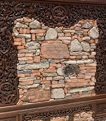 Broken bricks and stones show the destructive nature, but they are framed by lovely wooden carvings.