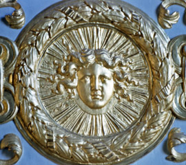 the face of Louis XIV as the Sun King as a gold medallion